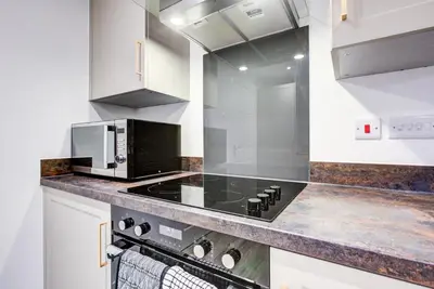 a kitchen with a stove and a microwave at Entire house in Stanway, Colchester in Colchester