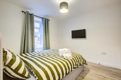 a stuffed animal sitting on a bed in a bedroom at Entire house in Stanway, Colchester in Colchester