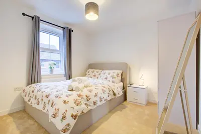 a white bedroom with a bed and a window at Entire house in Stanway, Colchester in Colchester