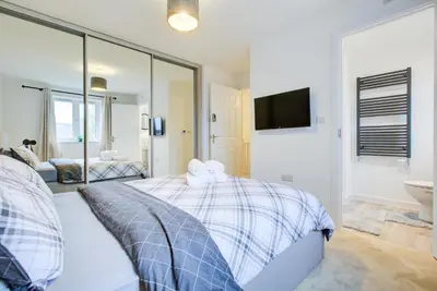 a bedroom with a bed and a sink and a mirror at Entire house in Stanway, Colchester in Colchester