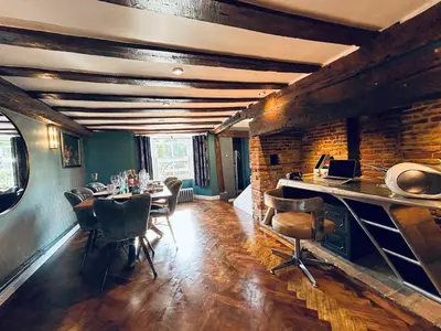 a dining room with a table and chairs and a brick wall at The Foremans House, With Hot Tub, A luxurious Historical pre 16th Century Grade II Listed House, location Essex in a picturesque Village, Country Pub In walking Distance in Ridgewell