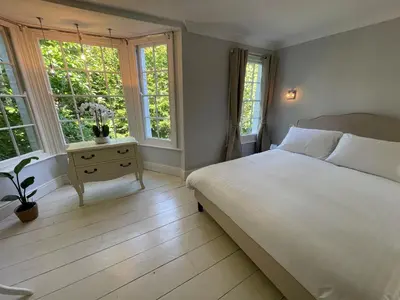 a bedroom with a white bed and two windows at Elegant Victorian house - very best central location in historical city centre in Cambridge