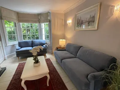 a living room with a blue couch and a table at Elegant Victorian house - very best central location in historical city centre in Cambridge