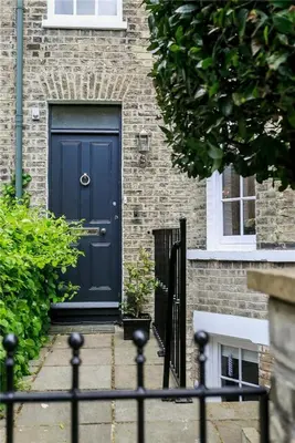 a blue door on a brick building with a fence at Elegant Victorian house - very best central location in historical city centre in Cambridge