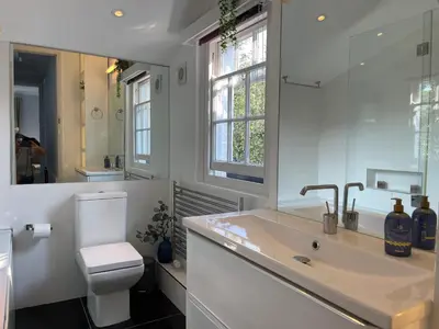 a bathroom with a sink and a toilet and a mirror at Elegant Victorian house - very best central location in historical city centre in Cambridge