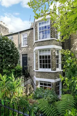 a brick house with a black door and windows at Elegant Victorian house - very best central location in historical city centre in Cambridge