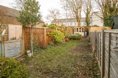 a backyard with a fence and a yard withgrass at Cosy House - Stanstead Airport in Bishops Stortford