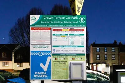 a sign for a parking meter in a parking lot at Cosy House - Stanstead Airport in Bishops Stortford