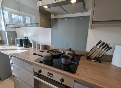 a kitchen with a stove with pots and pans on it at Newly Built Thetford Retreat in Watton