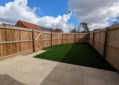 a backyard with a wooden fence and green grass at Newly Built Thetford Retreat in Watton