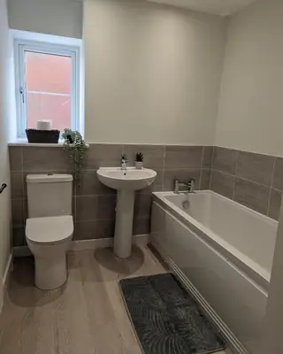 a bathroom with a toilet and a sink and a bath tub at Newly Built Thetford Retreat in Watton