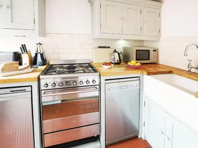 a kitchen with a stove and a sink at Tiger Villa by The Suffolk Cottage Collection in Aldeburgh