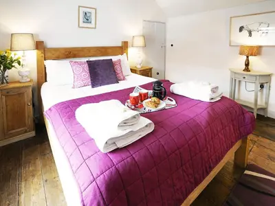 a bedroom with two beds with a purple blanket at Tiger Villa by The Suffolk Cottage Collection in Aldeburgh
