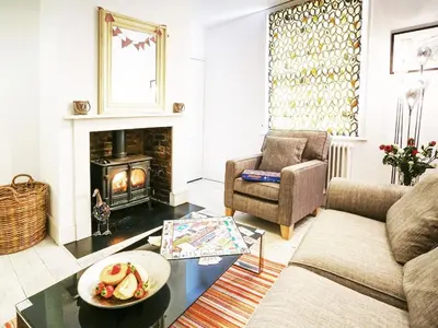 a living room with a couch and a fireplace at Sandpiper Cottage by The Suffolk Cottage Collection in Aldeburgh