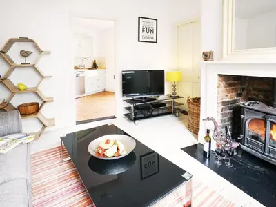 a living room with a bowl of fruit on a table at Sandpiper Cottage by The Suffolk Cottage Collection in Aldeburgh