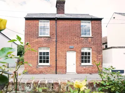 an old brick house with a white door at Sandpiper Cottage by The Suffolk Cottage Collection in Aldeburgh
