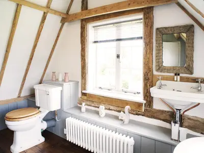 a bathroom with a toilet and a sink and a window at The Cottage by The Suffolk Cottage Collection in Peasenhall