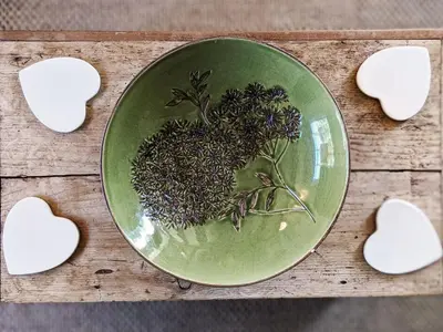 a green plate on a wooden table with cookies at The Cottage by The Suffolk Cottage Collection in Peasenhall