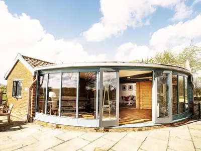 an extension to a house with sliding glass doors at The Seed Store by The Suffolk Cottage Collection in Peasenhall