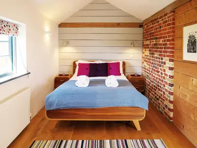 a bedroom with a bed with two towels on it at The Seed Store by The Suffolk Cottage Collection in Peasenhall