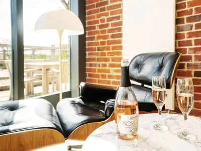 a bottle of wine on a table with two glasses at The Seed Store by The Suffolk Cottage Collection in Peasenhall