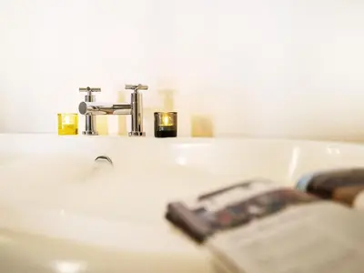 a bathroom sink with a faucet and a newspaper at The Seed Store by The Suffolk Cottage Collection in Peasenhall