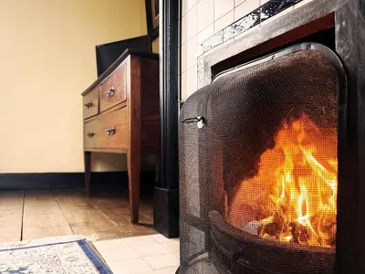 a fire in a fireplace in a living room at The Vintage House by The Suffolk Cottage Collection in Aldeburgh