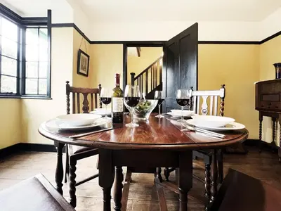 a dining room table with glasses of wine on it at The Vintage House by The Suffolk Cottage Collection in Aldeburgh