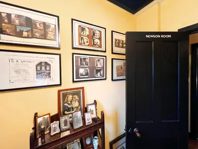 a room with pictures on the wall and a black door at The Vintage House by The Suffolk Cottage Collection in Aldeburgh
