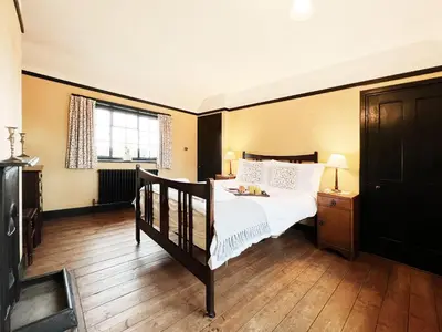 a bedroom with a bed and a window at The Vintage House by The Suffolk Cottage Collection in Aldeburgh