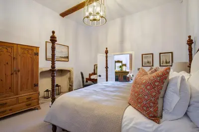 a bedroom with a bed and a chandelier at Gatehouse East in Saint Osyth
