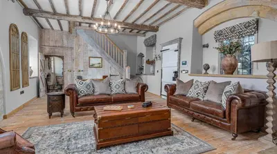 a living room with leather couches and a table at Gatehouse East in Saint Osyth