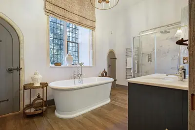 a bathroom with a large tub and two sinks and a window at Gatehouse East in Saint Osyth