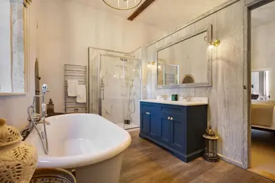 a bathroom with a tub and a sink and a shower at Gatehouse East in Saint Osyth