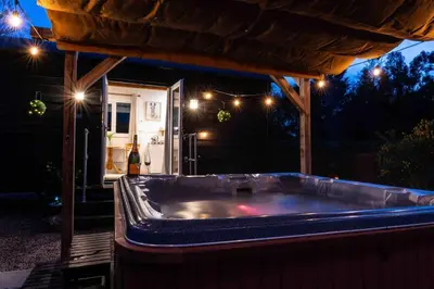 a hot tub in a backyard at night with lights at Back in Thyme in Colchester