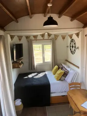 a bedroom with a bed with a window and a table at Back in Thyme in Colchester