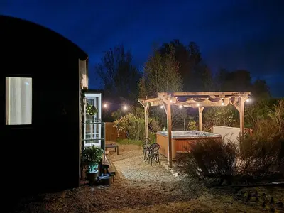 a backyard at night with a pergola and a tub at Back in Thyme in Colchester