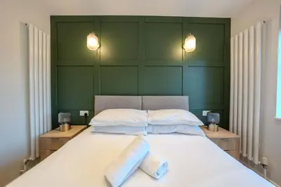 a bedroom with a large bed with two pillows at Beautiful 2 Bedroom Home in Cambridge