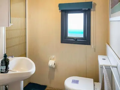 a bathroom with a sink and a toilet and a window at The Fox - Uk48554 in Colchester