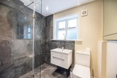 a bathroom with a toilet and a glass shower at Castle Cottage, Orford in Orford