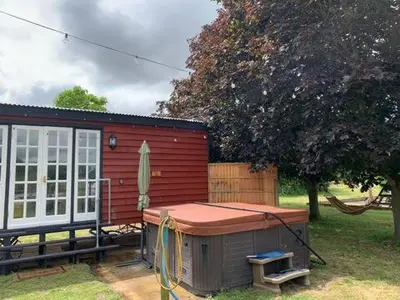 a small red shed with a table in the yard at M Lodge in Colchester
