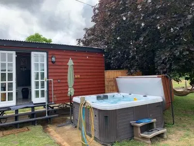 a hot tub in a yard next to a house at M Lodge in Colchester