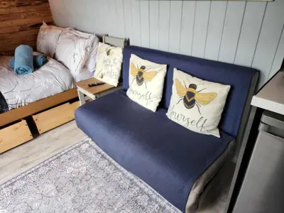 a room with a bed and a couch with pillows at M Lodge in Colchester