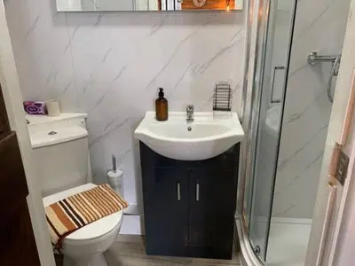 a bathroom with a sink and a shower and a toilet at M Lodge in Colchester