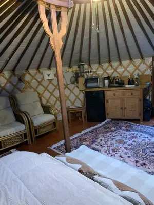 a room with a bed and chairs in a yurt at The Roundhouse Yurt in Colchester