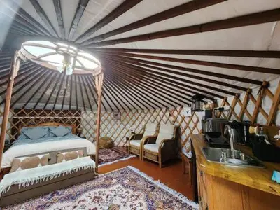 a bedroom with a bed and a sink in a room at The Roundhouse Yurt in Colchester