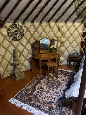 a room with a yurt with a table and a mirror at The Roundhouse Yurt in Colchester