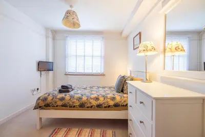 a bedroom with a bed and a desk and a mirror at Kiln House, Snape Maltings in Snape