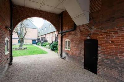 an archway in a brick building with a door at Kiln House, Snape Maltings in Snape