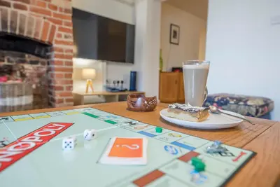 a table with a board game and a drink on it at Kiln House, Snape Maltings in Snape